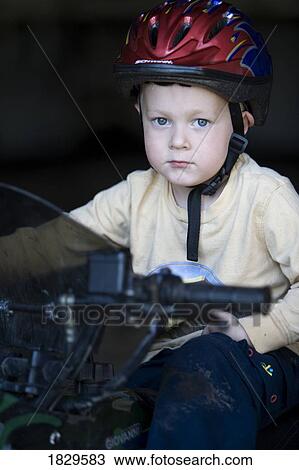 A young boy wearing a helmet View Large Photo Image Stock Image - A young boy wearing a helmet. Fotosearch