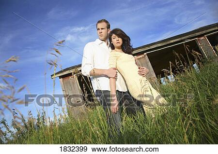 Stock Photo - A Young Couple Standing In Front Of A Shack. Fotosearch