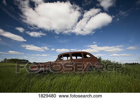 Stock Image - An abandoned classic car in a prairie field. Fotosearch