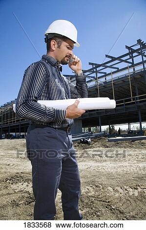 Architect on the phone at building site View Large Photo Image Stock Photo - Architect on the phone at building site. Fotosearch