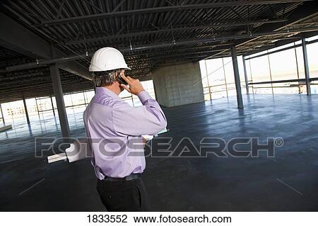 Architect with blueprint and cell phone View Large Photo Image Stock Image - Architect with blueprint and cell phone. Fotosearch