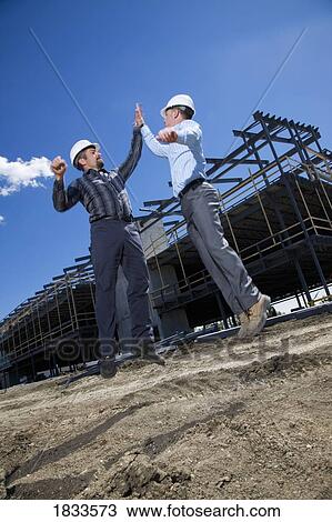 Architects celebrating with each other on building site View Large Photo Image Stock Image - Architects celebrating with each other on building site. Fotosearch