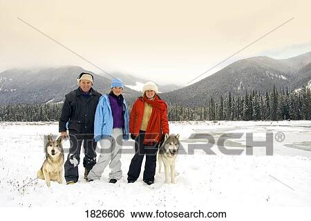 Stock Photograph - Australian tourists in British Columbia, Canada, standing next to wolves. Fotosearch