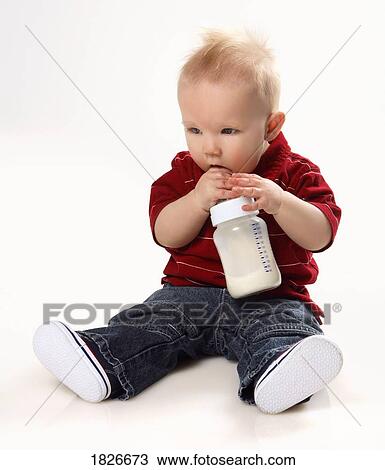 Stock Image - Baby boy with a bottle of milk. Fotosearch