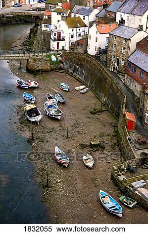 Stock Photography - Boats beached on the riverbank, Staithes, North Yorkshire, England. Fotosearch