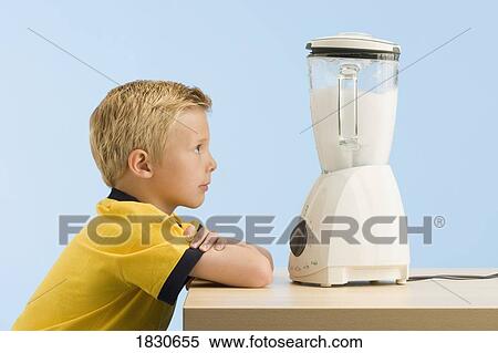 Stock Photography - Boy looking at a blender. Fotosearch