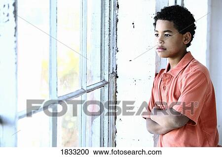 Stock Image - Boy looking out of window. Fotosearch