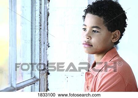 Stock Image - Boy looking out the window. Fotosearch