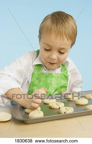 Boy making cookies View Large Photo Image Stock Photo - Boy making cookies. Fotosearch