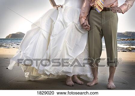 Bride and groom holding hands on beach View Large Photo Image Stock Image - Bride and groom holding hands on beach. Fotosearch