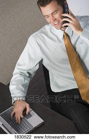 Businessman on the phone and his laptop View Large Photo Image Stock Image - Businessman on the phone and his laptop. Fotosearch