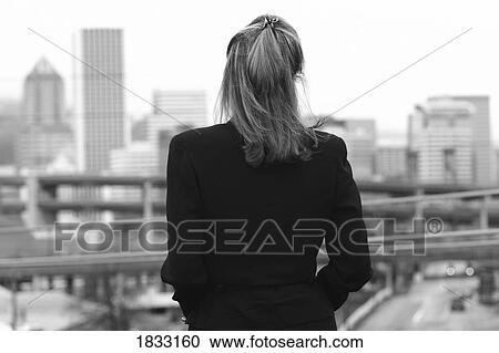 Stock Image - Businesswoman looking at cityscape. Fotosearch