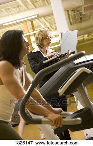 Businesswoman using a computer while on the treadmill View Large Photo Image Stock Photo - Businesswoman using a computer while on the treadmill. Fotosearch