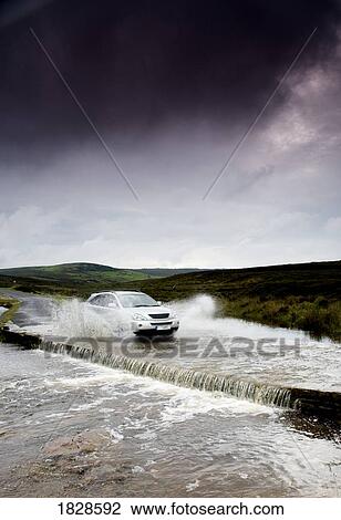 Car driving down flooded road, Yorkshire, England View Large Photo Image Stock Image - Car driving down flooded road, Yorkshire, England. Fotosearch