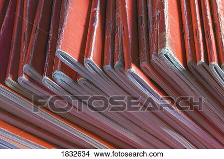 Picture - Collection of well used red notebooks . Fotosearch