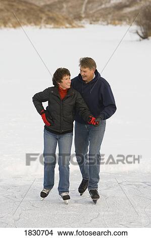 Couple ice skating together View Large Photo Image Picture - Couple ice skating together. Fotosearch