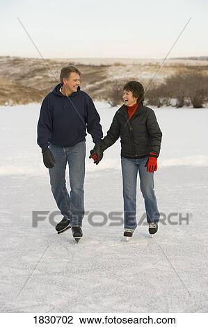 Stock Image - Couple ice skating together. Fotosearch