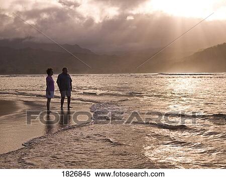 Stock Photography - Couple on the beach in Kauai, Hawaii, USA. Fotosearch