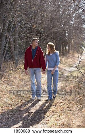 Couple walking while holding hands View Large Photo Image Stock Photo - Couple walking while holding hands. Fotosearch