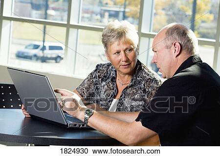 Stock Image - Couple working on a laptop. Fotosearch