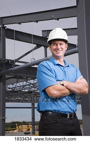 Picture - Engineer leaning against metal beam. Fotosearch
