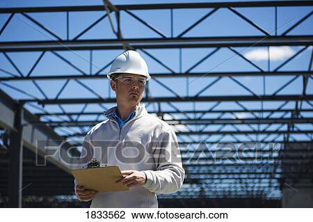 Engineer with clipboard on construction site View Large Photo Image Stock Image - Engineer with clipboard on construction site. Fotosearch