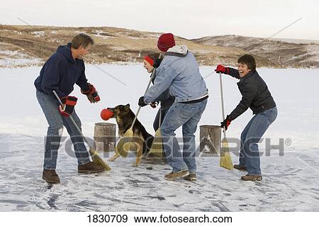 Stock Photo - Family playing broomball together. Fotosearch