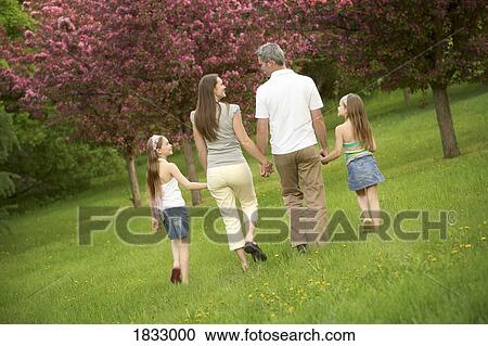 Stock Image - Family walking in a park. Fotosearch