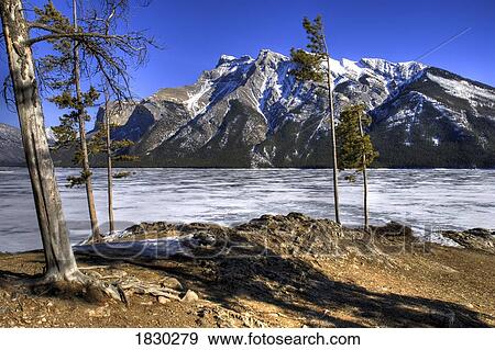 Stock Photo - Frozen Lake Minnewanka and Mount Inglismaldie, Banff National Park, Alberta, Canada. Fotosearch