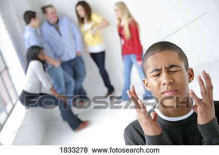 Stock Photo - Frustrated boy apart from friends. Fotosearch