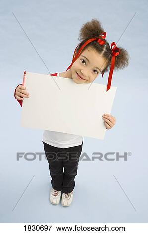 Girl holding up a book View Large Photo Image Stock Photo - Girl holding up a book. Fotosearch