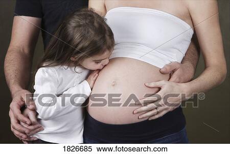 Stock Photography - Girl kissing pregnant mother. Fotosearch