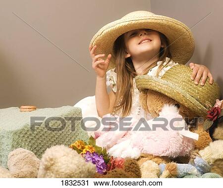 Girl playing with teddy bear and straw hats View Large Photo Image Stock Image - Girl playing with teddy bear and straw hats. Fotosearch