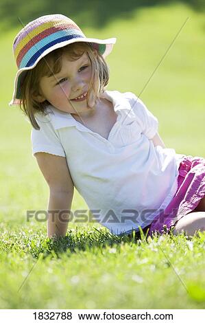 Stock Photo - Girl sitting on grass. Fotosearch