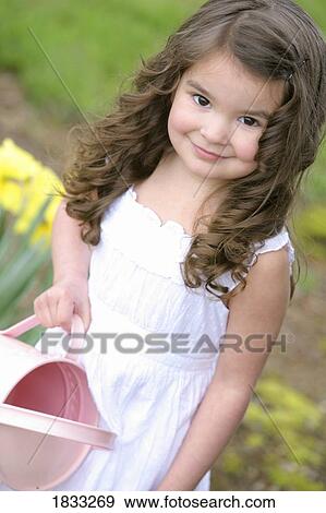 Girl watering daffodils with a pink watering can View Large Photo Image Stock Photo - Girl watering daffodils with a pink watering can. Fotosearch