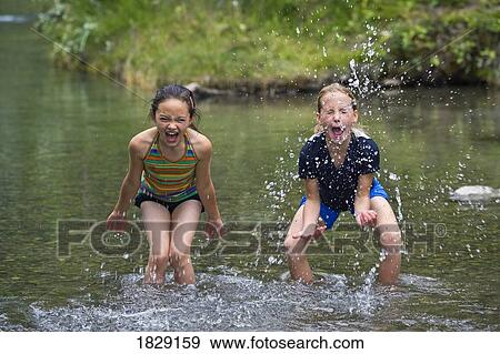 Stock Photo - Girls playing in water. Fotosearch