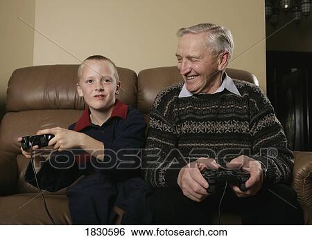 Grandfather and Grandson playing a game View Large Photo Image Stock Photograph - Grandfather and Grandson playing a game. Fotosearch