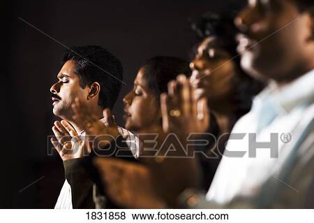 Stock Photo - Group praying. Fotosearch