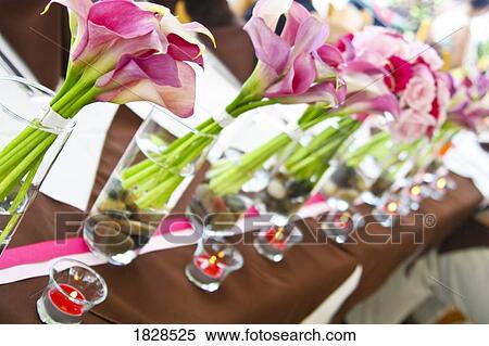 Stock Photography - Lilies in vases next to votive candles. Fotosearch