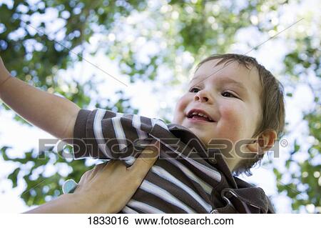 Stock Photograph - Little boy being lifted up. Fotosearch