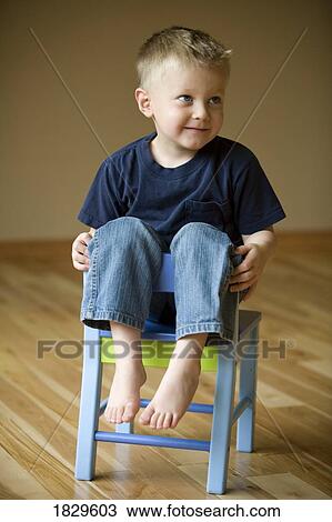 Little boy sitting on a chair View Large Photo Image Stock Image - Little boy sitting on a chair. Fotosearch