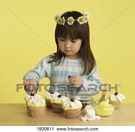 Little girl decorating cupcakes View Large Photo Image Stock Image - Little girl decorating cupcakes. Fotosearch