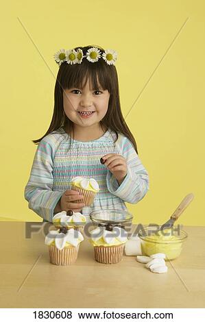 Little girl decorating cupcakes View Large Photo Image Stock Photo - Little girl decorating cupcakes. Fotosearch