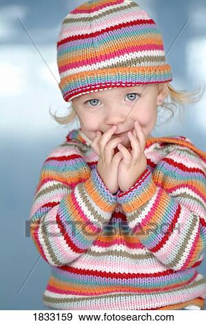Stock Photo - Little girl in colorful hat and sweater. Fotosearch