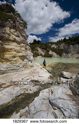 Stock Photo - Man at geothermal site, Wai-O-Tapu Thermal Wonderland on North Island of New Zealand. Fotosearch