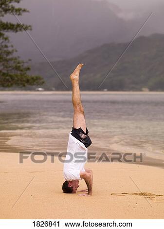 Man doing headstand on beach, Kauai, Hawaii, USA View Large Photo Image Stock Image - Man doing headstand on beach, Kauai, Hawaii, USA. Fotosearch
