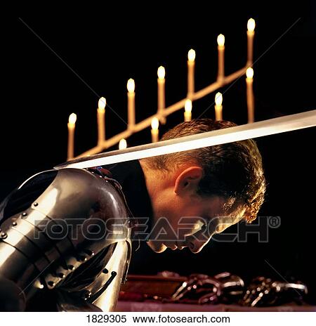 Stock Photography - Man in armor being knighted, side view. Fotosearch