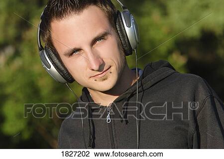 Stock Image - Man listening through headphones. Fotosearch