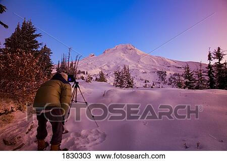 Man photographing landscape at sunset, Mount Hood, Oregon, USA View Large Photo Image Stock Image - Man photographing landscape at sunset, Mount Hood, Oregon, USA. Fotosearch