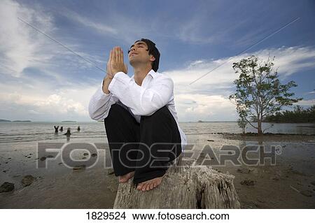 Picture - Man praying by the beach, Koh Lanta, Thailand, Asia. Fotosearch